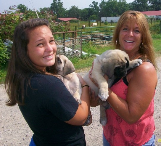 Two women with the Haas puppies outside