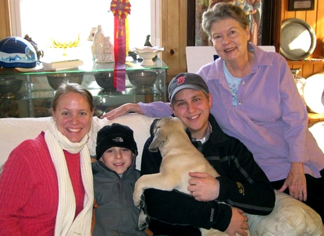 A family holding a dog named Isabelle on a couch