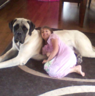 A little girl sleeping on a dog named Porter